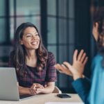 Businesswomen talking in the office with a laptop on the desk