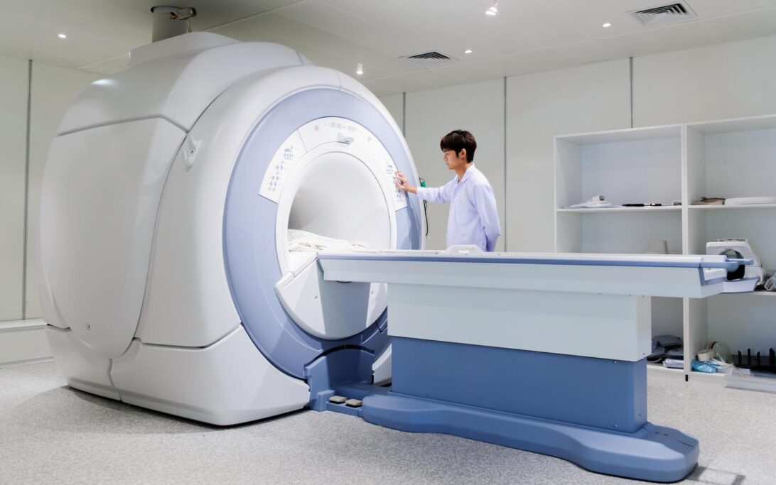 A medical professional stands by an MRI scanner