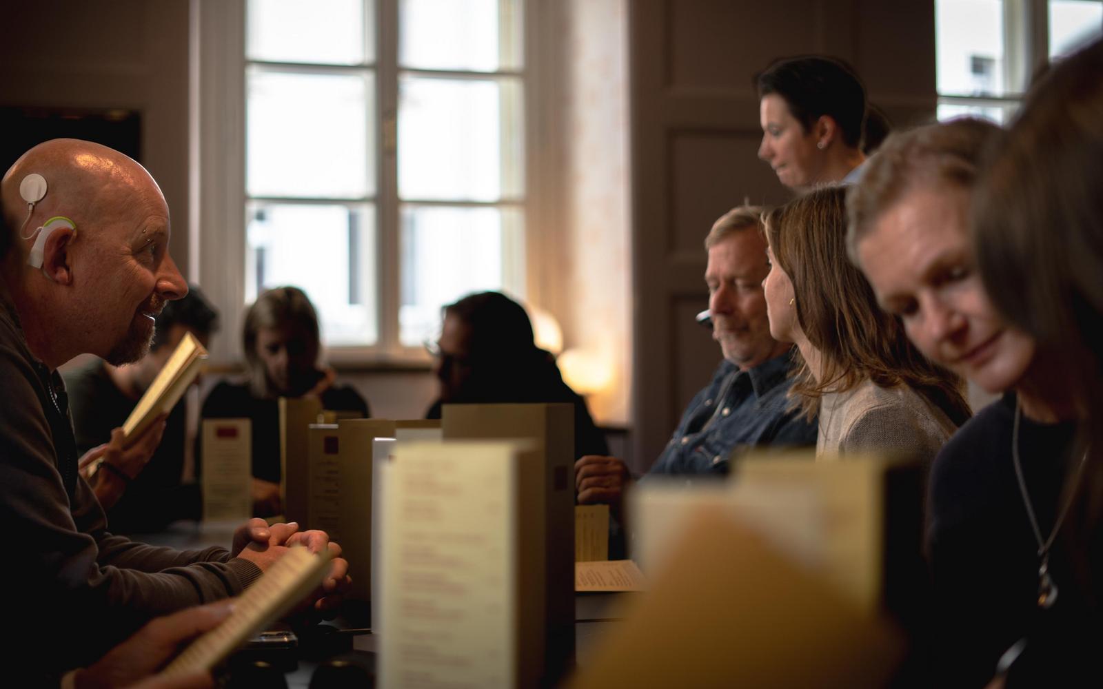 Restaurant setting. One white man has a cochlear implant.