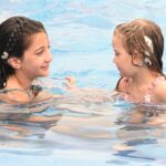 CI users Gabriella and Mia swimming with WaterWear