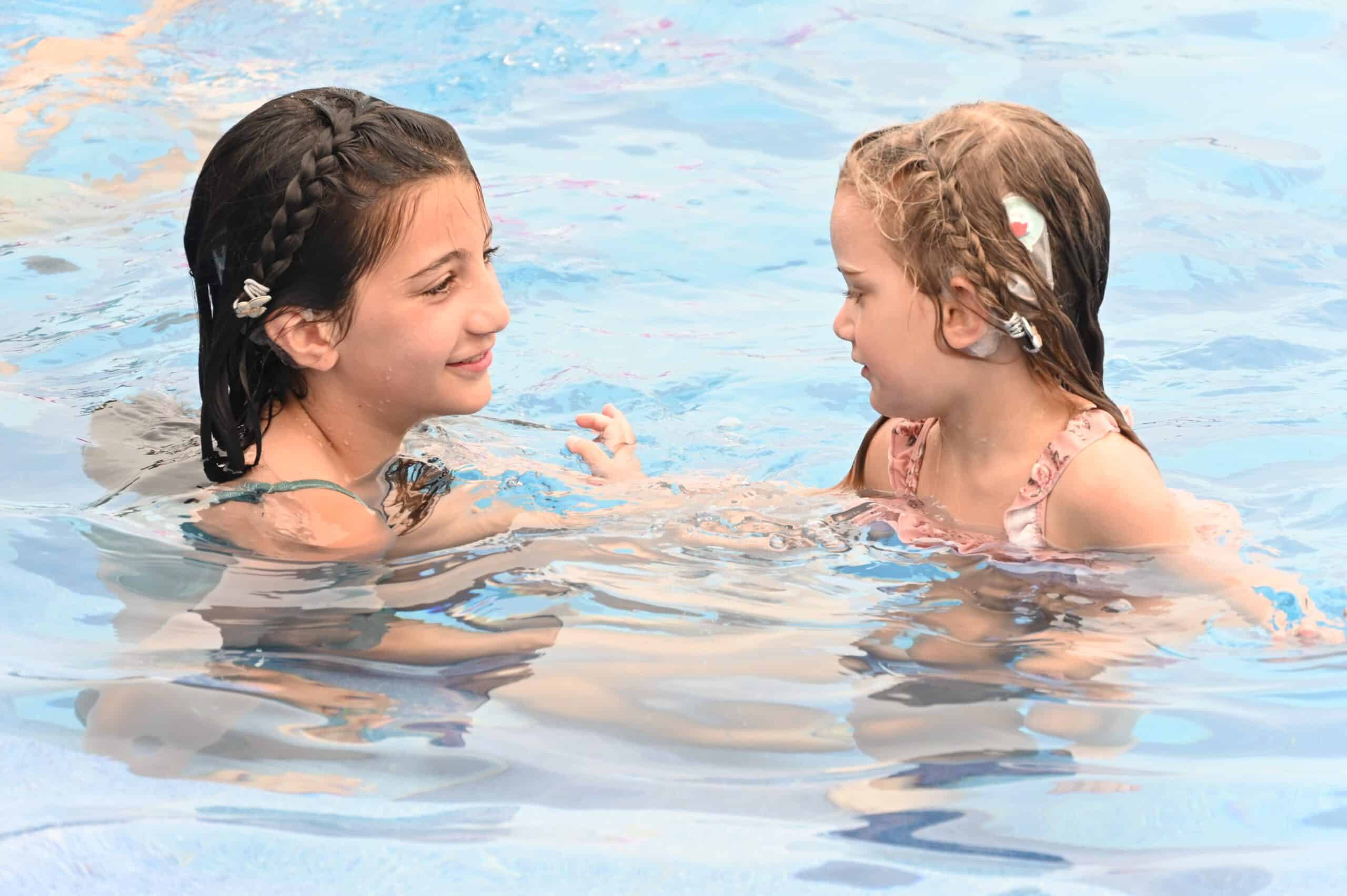 CI users Gabriella and Mia swimming with WaterWear