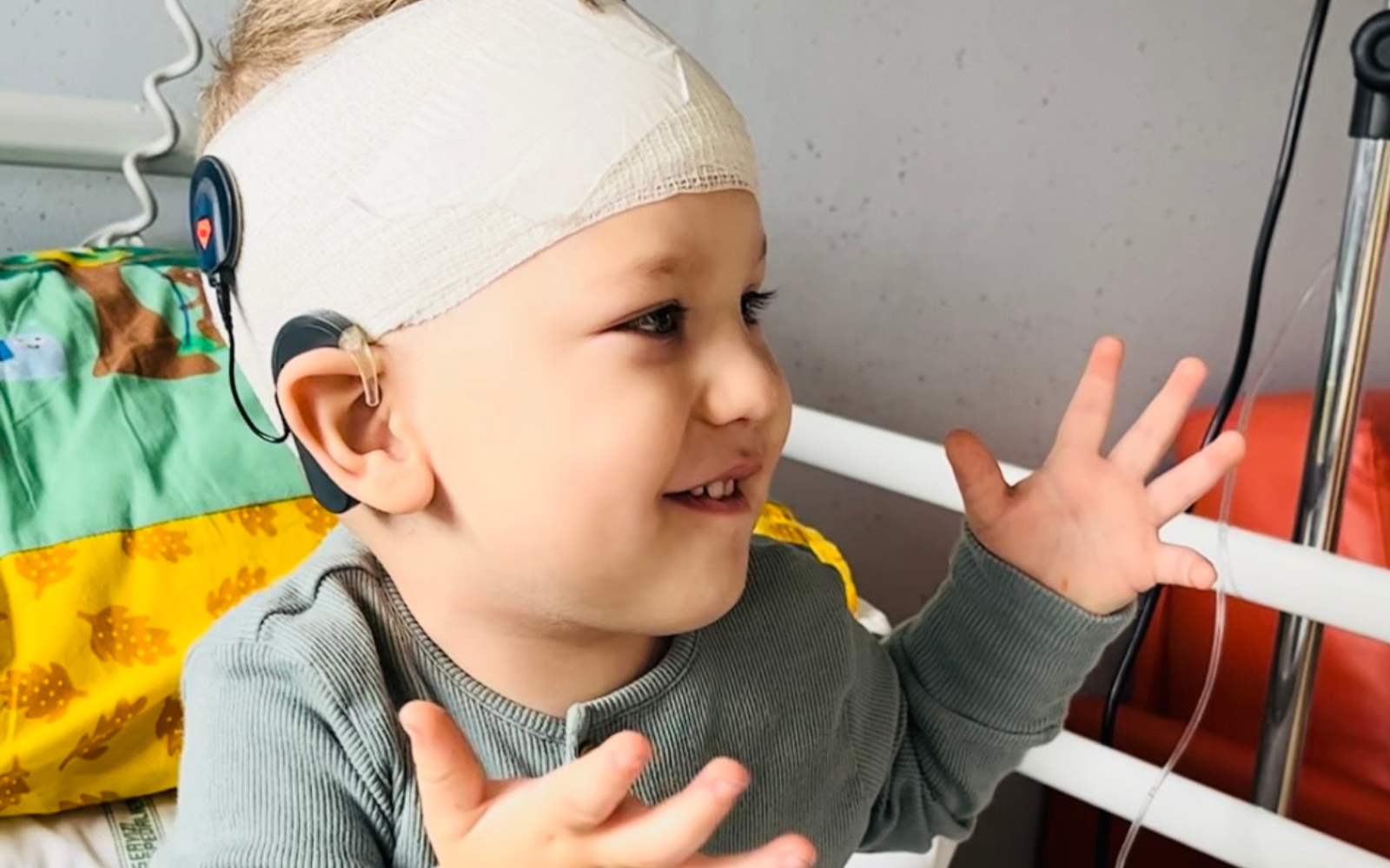 CI user Riccardo after cochlear implant activation, sitting in his hospital bed