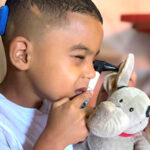 Davi brincando de médico examinando a boneca Mellie