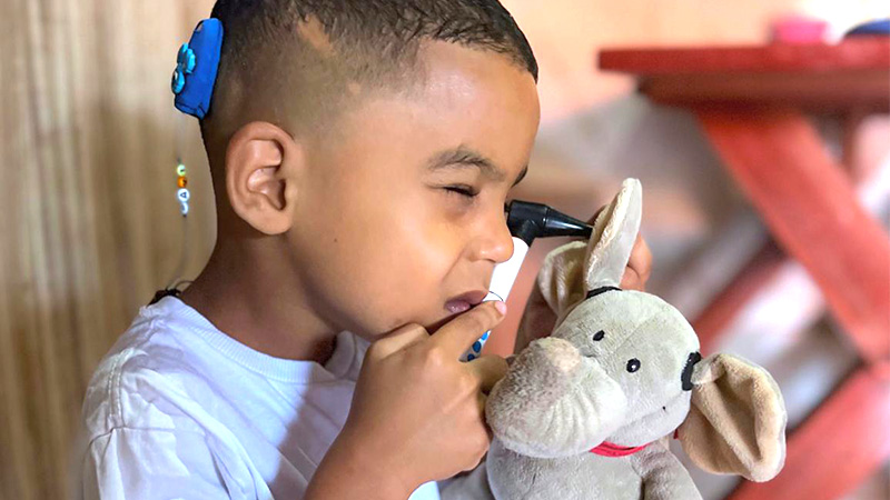 Davi brincando de médico examinando a boneca Mellie