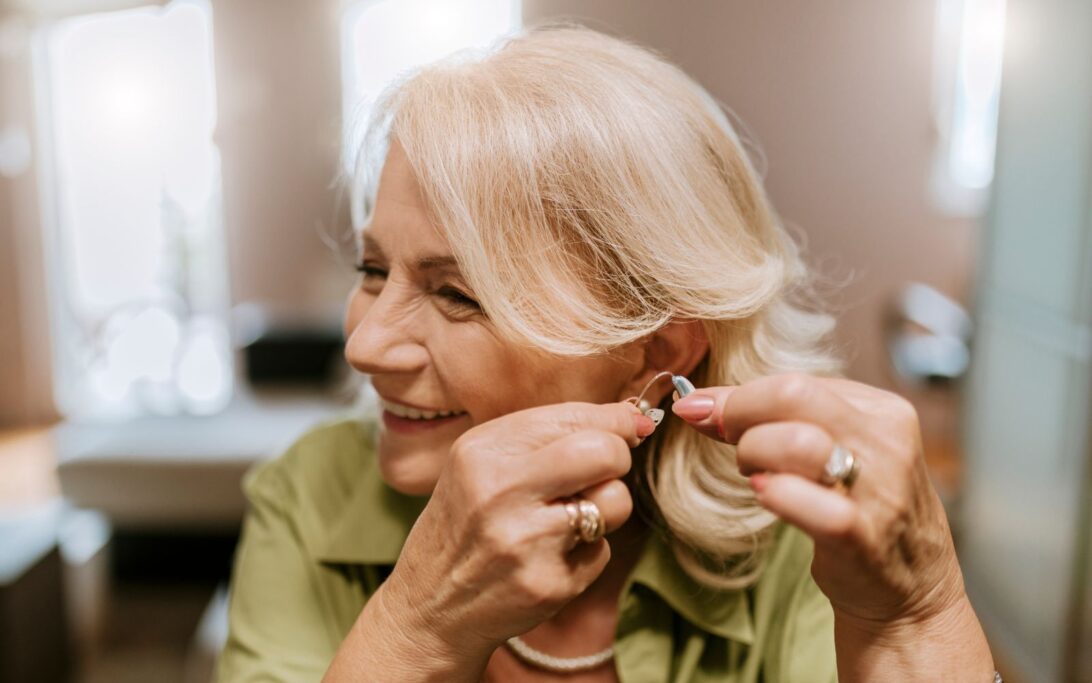 Eine ältere Damen probiert ein Hörgerät an