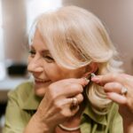 Eine ältere Damen probiert ein Hörgerät an