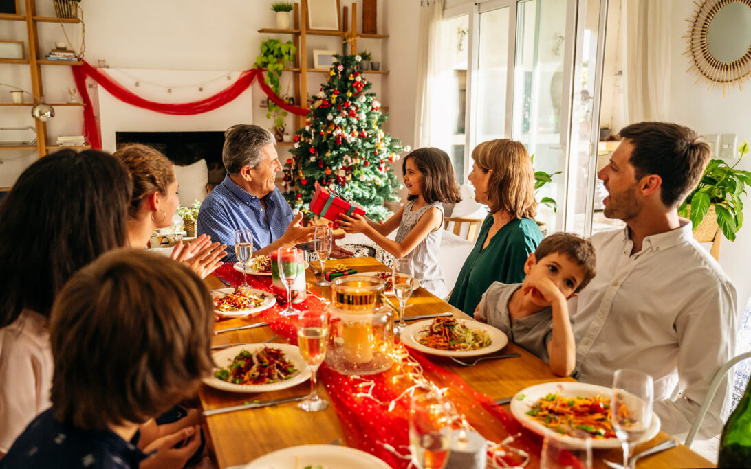 A family sitting around a table, celebrating the holidays