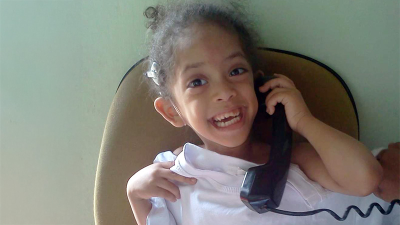 Clara ainda criança com implante coclear