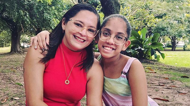 Clara com implante coclear e sua mãe