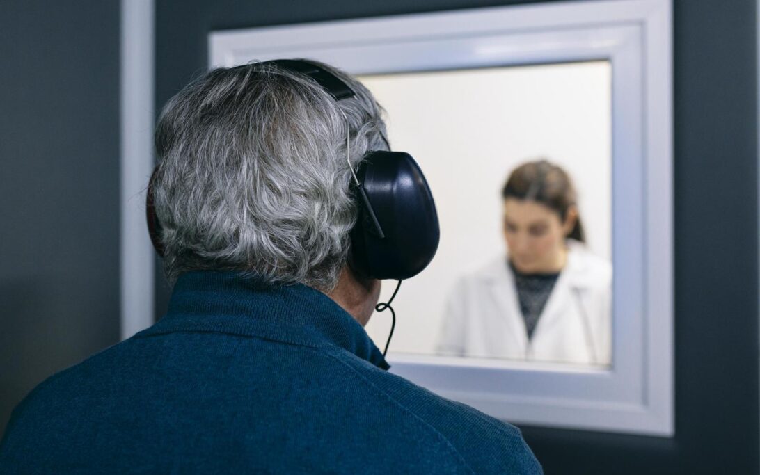 Doctor giving instructions to patient during a hearing test