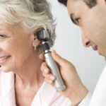 Orta yaşlı doktor yaşlı hastayı muayene ediyor