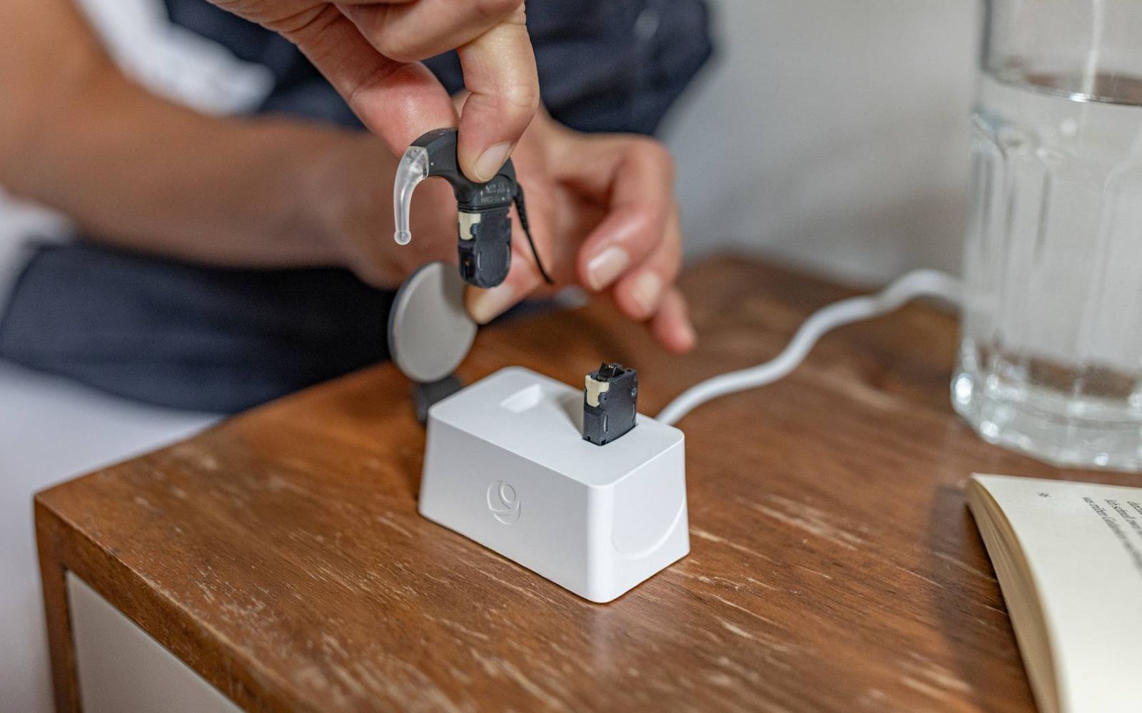 Person places SONNET 3 audio processor battery into charger