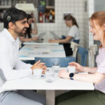 Two people with cochlear implants sitting in a restaurant and talking