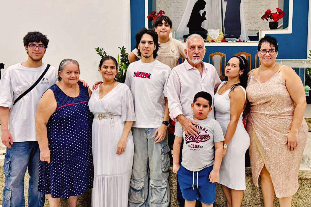 Karine em foto coletiva com outras pessoas dentro da igreja.