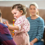 A toddler playing with her parents