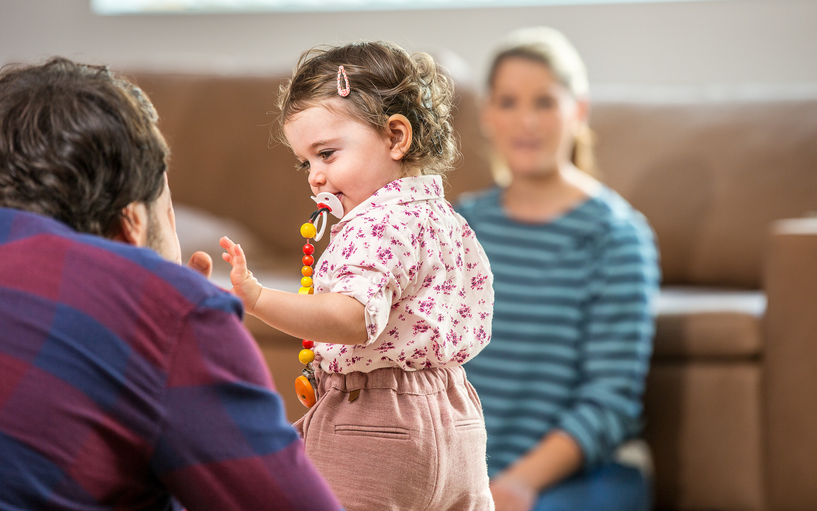 A toddler playing with her parents