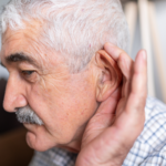 Older man holding his ear