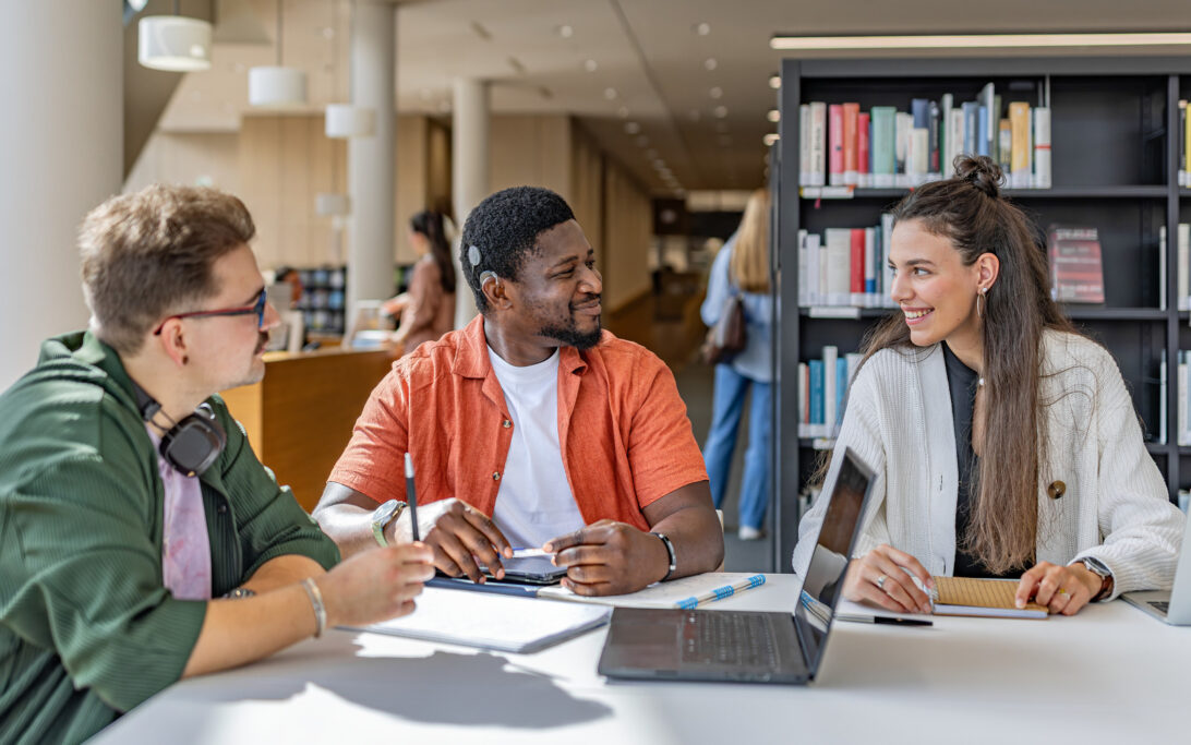 A CI user talking to his friends in a library