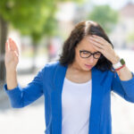 Eine Frau mit Meniere-Krankheit, die eine Schwindelattacke erlebt